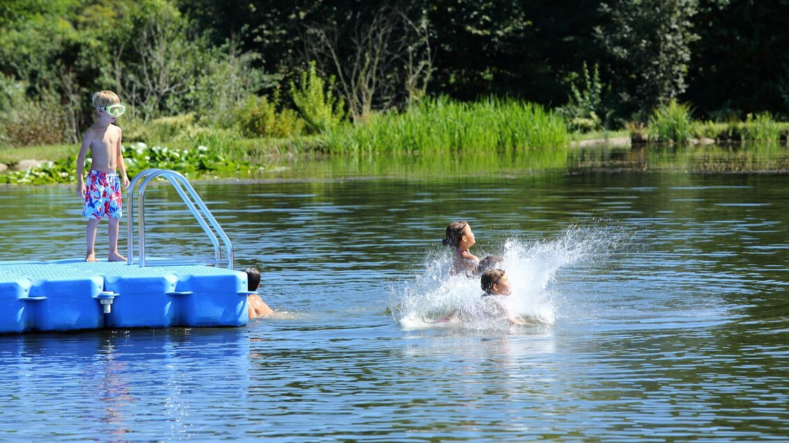 Ein schöner Sommermorgen an einem klaren Gewässer. Kinder schwimmen und spielen am Steg. | © Edi Aldrian