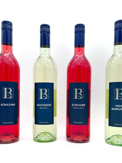 Four bottles of wine are standing next to each other. The varieties are Schilcher, Sauvignon Blanc, Schilcher Exklusiv, and Weiß Burgunder. | © Familie Brauchart