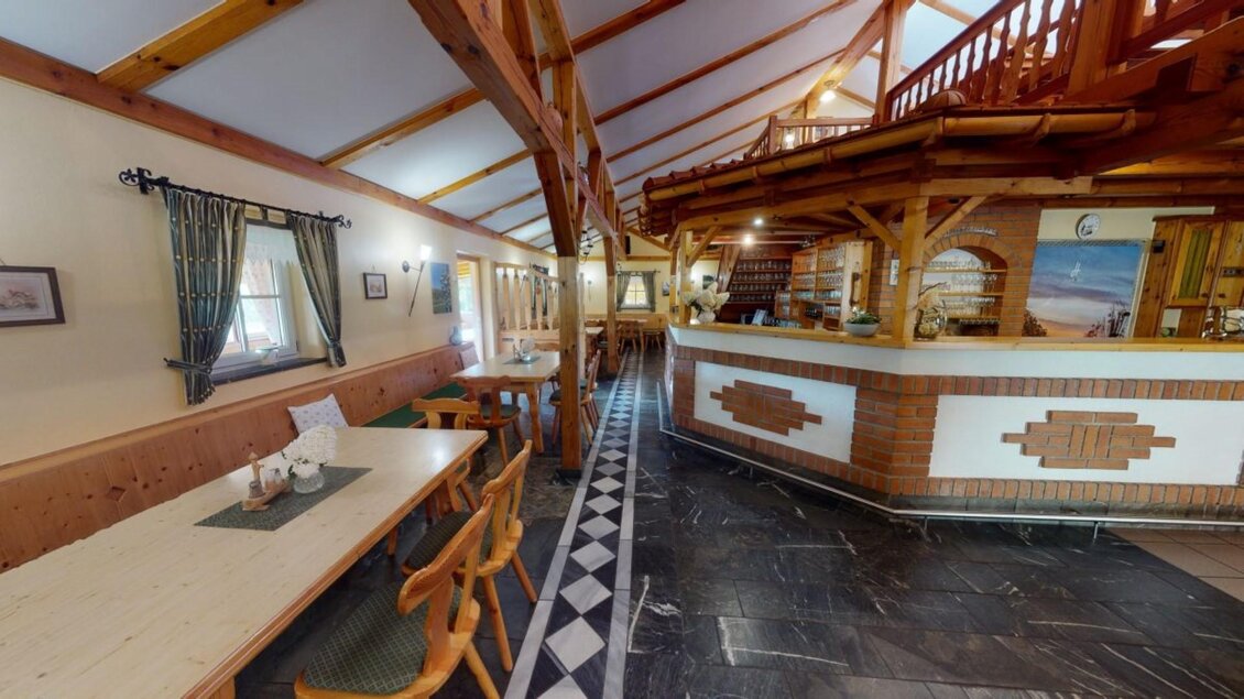 Ein einladendes Restaurant mit Holzverkleidung und gemütlichen Tischen. Im Hintergrund ist die Theke sichtbar, die für eine freundliche Atmosphäre sorgt. | © Familie Haring