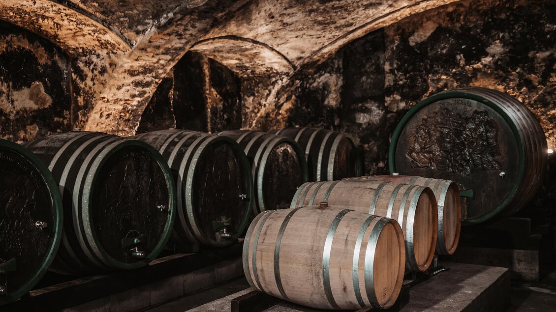 Ein traditioneller Weinkeller mit großen Holzfässern. Die Wände sind aus Stein, und die Atmosphäre ist gemütlich und rustikal. | © MichaelaLorber/WeingutJöbstl