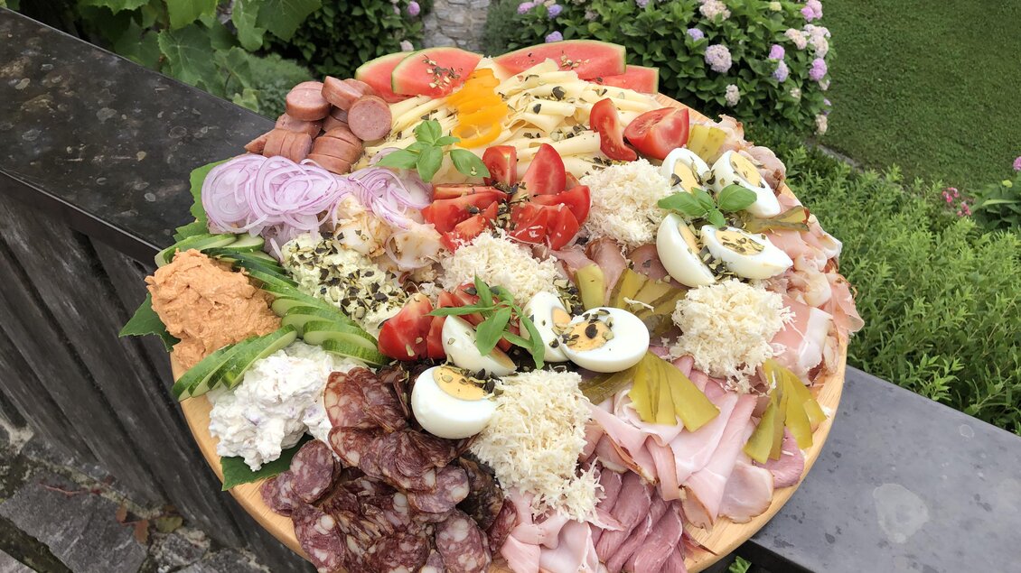 Ein reichhaltiges Wurst- und Käsebrett mit frischem Gemüse und Eiern. Farbenfrohe Zutaten auf einem Holzbrett, perfekt für ein Buffet oder ein Picknick. | © Klapotetzhof Silberschneider- Brigitte Maier
