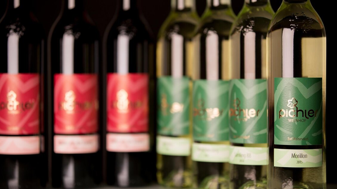 Eine Auswahl an Weinflaschen in verschiedenen Farben und Designs. Die Flaschen sind in zwei Gruppen angeordnet, eine Gruppe mit roten und eine mit weißen Weinen. | © Christoph Pohlner