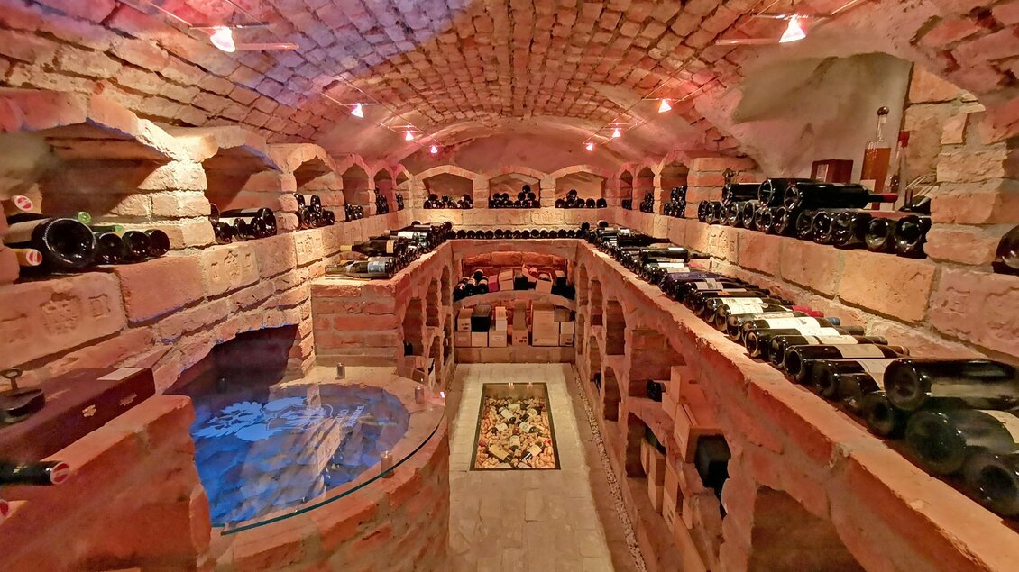 Eine Holzregal mit verschiedenen Weinflaschen. Die Flaschen sind ordentlich angeordnet und zeigen eine Auswahl an Weinen. | © Gasthaus Mossauer