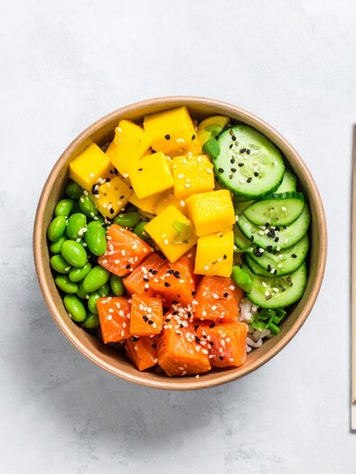 Colorful Poké Bowl with salmon, mango, edamame, and cucumbers, served in a bowl with chopsticks on the side | © Firefly - Benedikt Trummer
