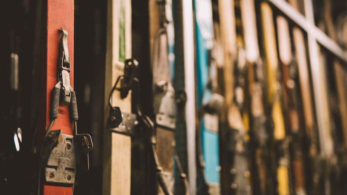 Eine Wand mit verschiedenen Skiern in unterschiedlichen Farben. Die Skier sind ordentlich angeordnet und zeigen ihre Bindungen. | © WinterSportMuseum