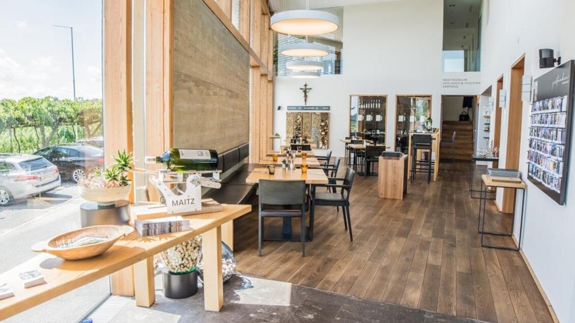 Ein modernes Café mit großen Fenstern und Holztischen. Es ist hell und einladend, mit einer schönen Aussicht auf die Umgebung. | © Magdalena Koinegg