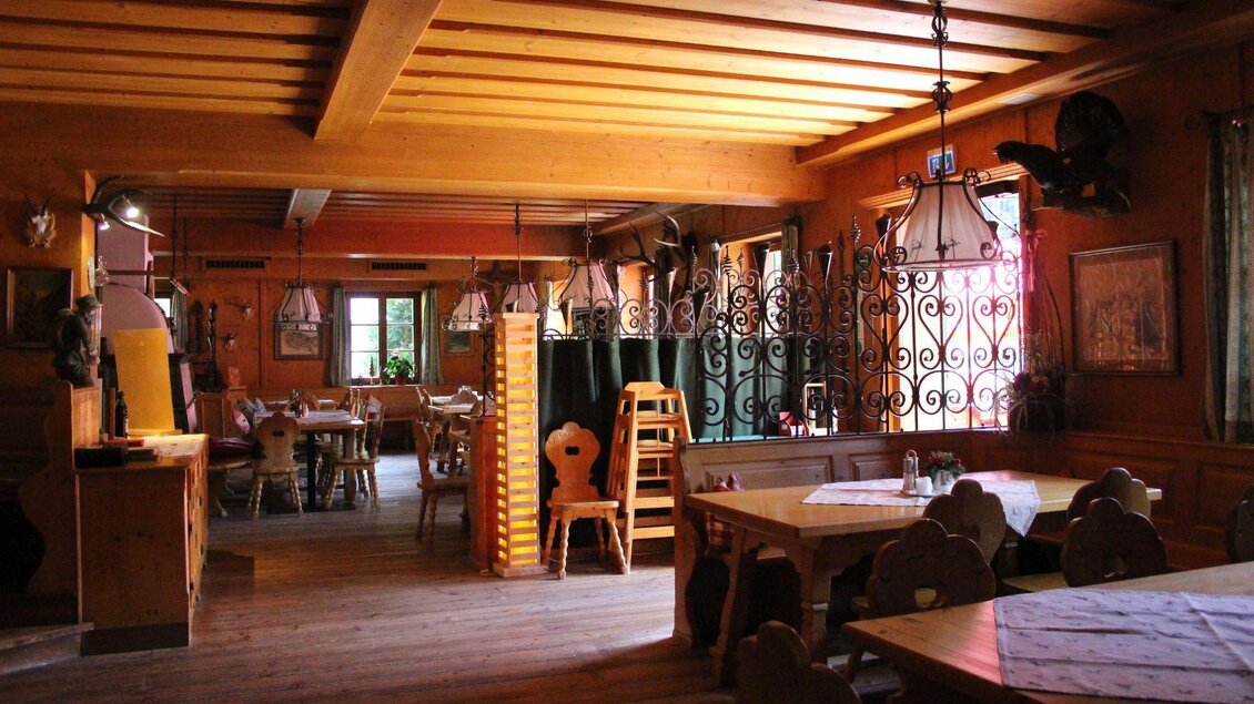 Ein gemütliches Restaurant mit Holzdekor und einigen Tischen. Sanftes Licht fällt durch die Fenster und schafft eine einladende Atmosphäre. | © Viola Lechner