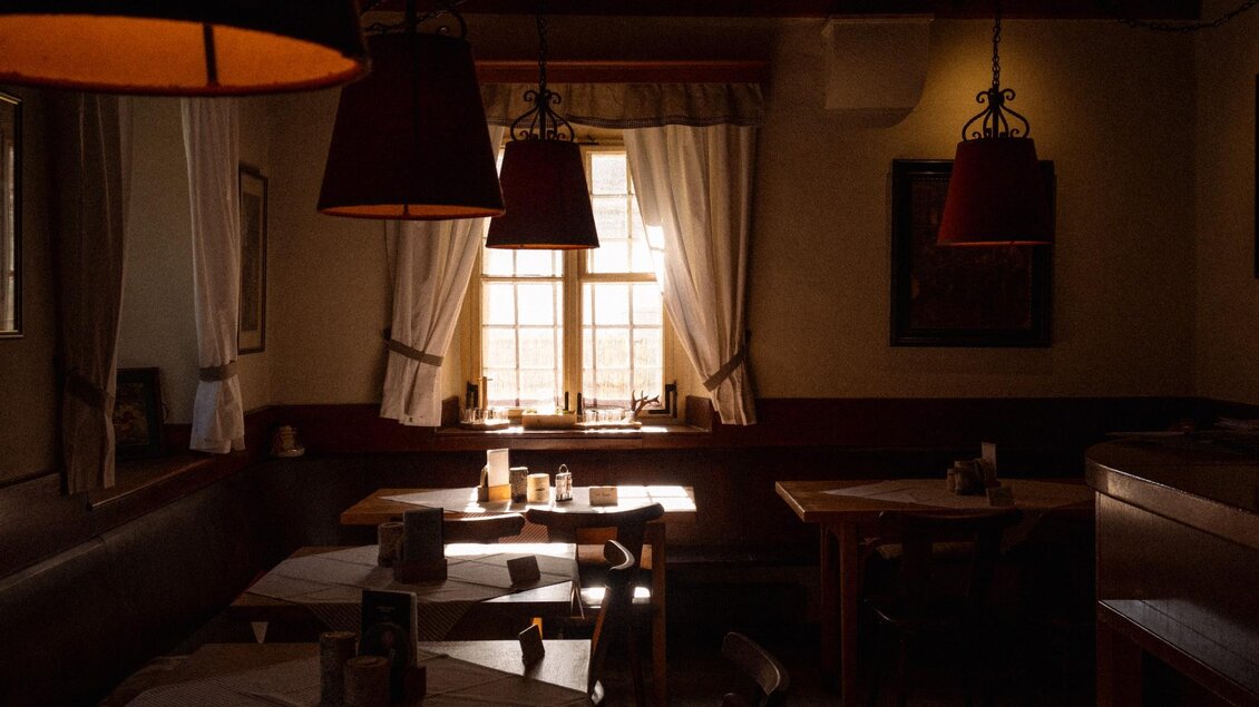Ein gemütliches Restaurant mit warmem Licht und Holzmöbeln. Die Fenster lassen sanftes Tageslicht herein, und die Atmosphäre ist einladend. | © Robert Bodnar