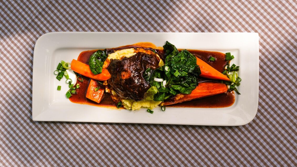 Geschmortes Fleisch mit Karotten, Spinat und Püree auf rechteckigem Teller | © Robert Bodnar