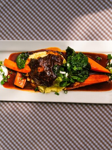Geschmortes Fleisch mit Karotten, Spinat und Püree auf rechteckigem Teller | © Robert Bodnar