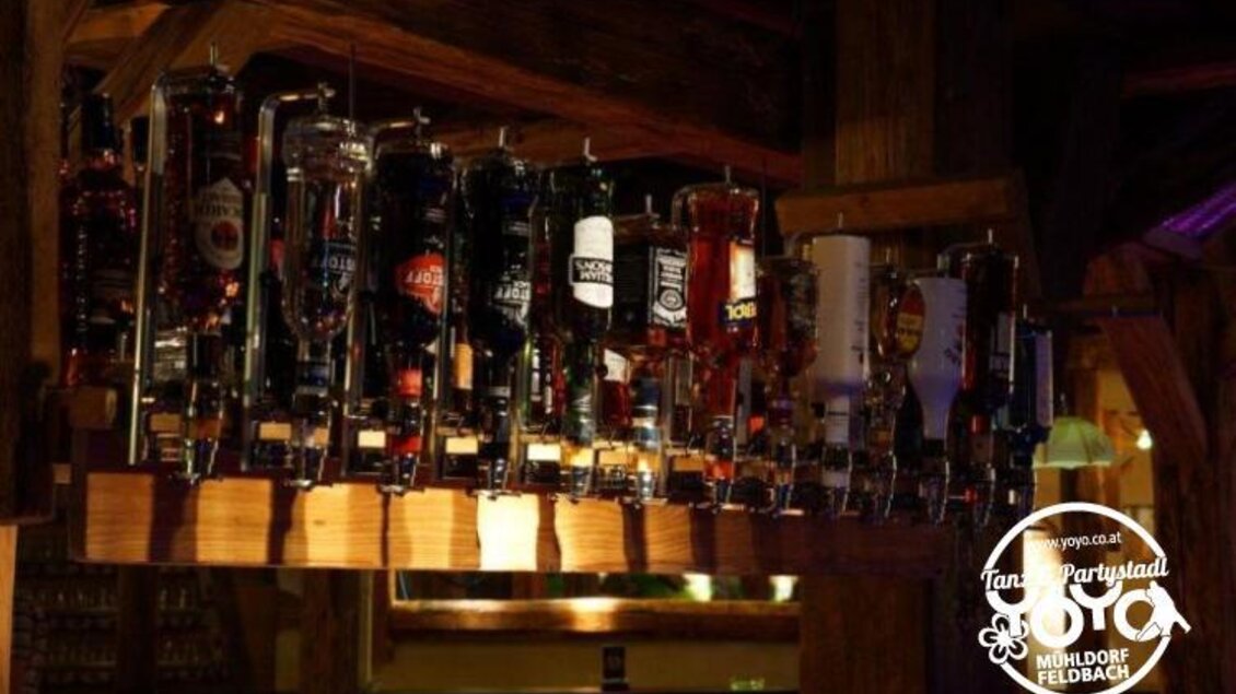 Eine gut bestückte Bar mit verschiedenen Getränken in Glaskaraffen. Das Ambiente ist gemütlich und einladend. | © Yoyo Feldbach