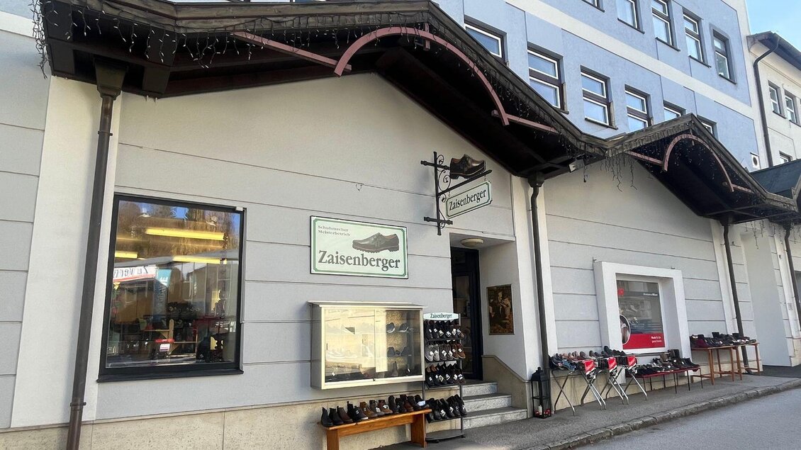Ein Schild für einen Schuhmacherbetrieb namens Zaisenberger. Es bietet Schuhhandel, Schuhherstellung und Reparaturen für Lederwaren an. | © TVB Ausseerland- Salzkammergut_Nathalie Schröttenhamer