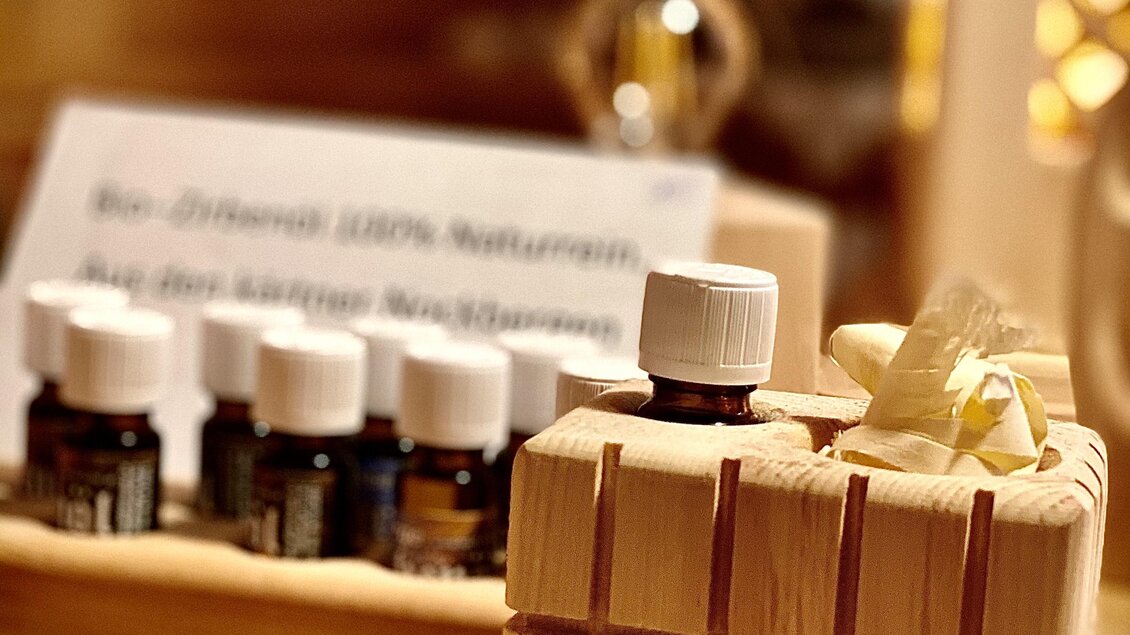 Ein schöner Holzkasten mit einem kleinen Geschenk und einigen Fläschchen ätherischer Öle im Hintergrund. Die Atmosphäre ist warm und einladend. | © Zirben Toni