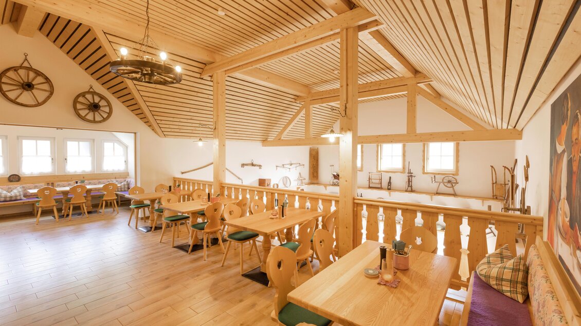 Ein gemütlicher Gastraum mit Holztischen und Stühlen. Die Decke ist aus Holz, und es gibt große Fenster, die viel Licht hereinlassen. | © Zloam Wirt, www.zloamwirt.at