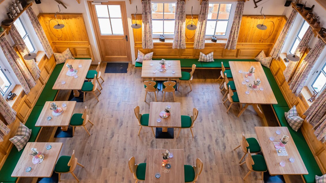 Ein gemütliches Restaurant mit Holzinterieur und mehreren Tischen. Die Tische sind ordentlich gedeckt und es gibt viel natürliches Licht. | © Zloam Wirt, www.zloamwirt.at