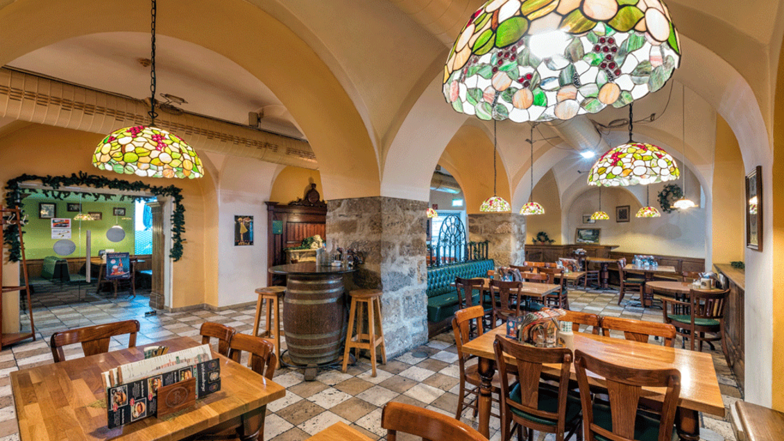 Ein gemütliches Restaurant mit Holztischen und bunten Lampenschirmen. Die Wände sind im traditionellen Stil dekoriert, und es herrscht eine einladende Atmosphäre. | © Zu den 3 goldenen Kugeln
