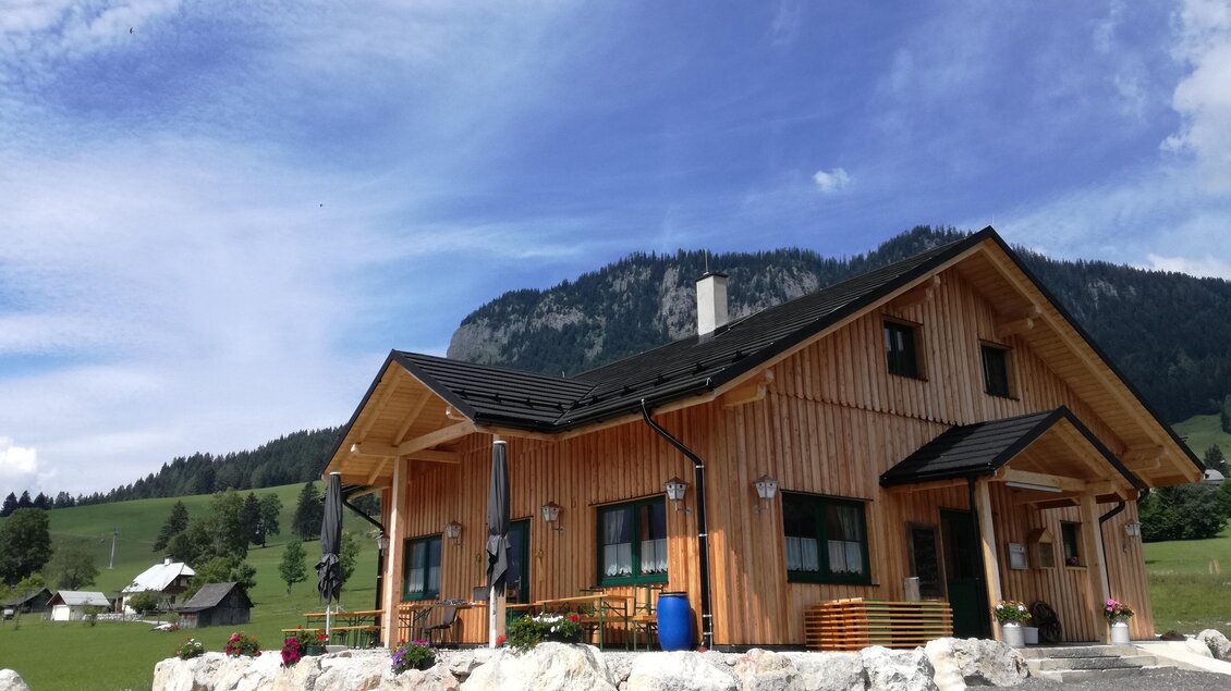 Ein gemütliches Holzhaus inmitten von grünen Wiesen und Bergen. Die Umgebung ist friedlich und einladend. | © Stoffis Hütten