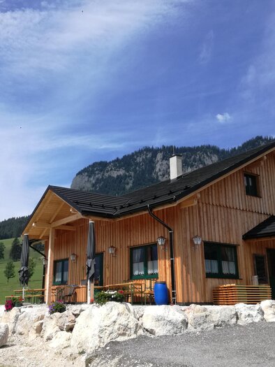Ein gemütliches Holzhaus inmitten von grünen Wiesen und Bergen. Die Umgebung ist friedlich und einladend. | © Stoffis Hütten