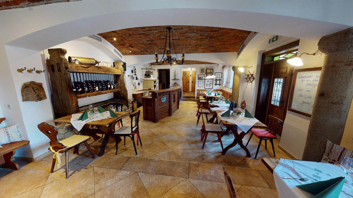 Ein gemütliches Restaurant mit Holzdekor und Tischen. Die Atmosphäre ist einladend und warm. | © Zur Schmied'n - 3D Blick