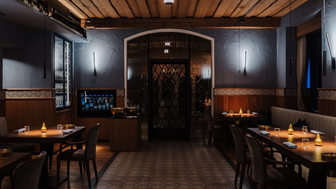 Elegant gedeckter Gastraum mit Holzbalkendecke und gedämpfter Beleuchtung | © Zur goldenen Birn