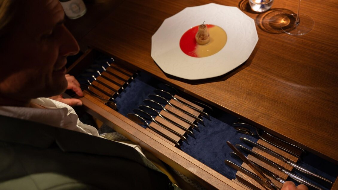 Gast wählt aus integrierter Bestecklade am Tisch ein Besteckstück zu seinem Dessert | © 5komma5sinne - Rene Strasser Fotografie