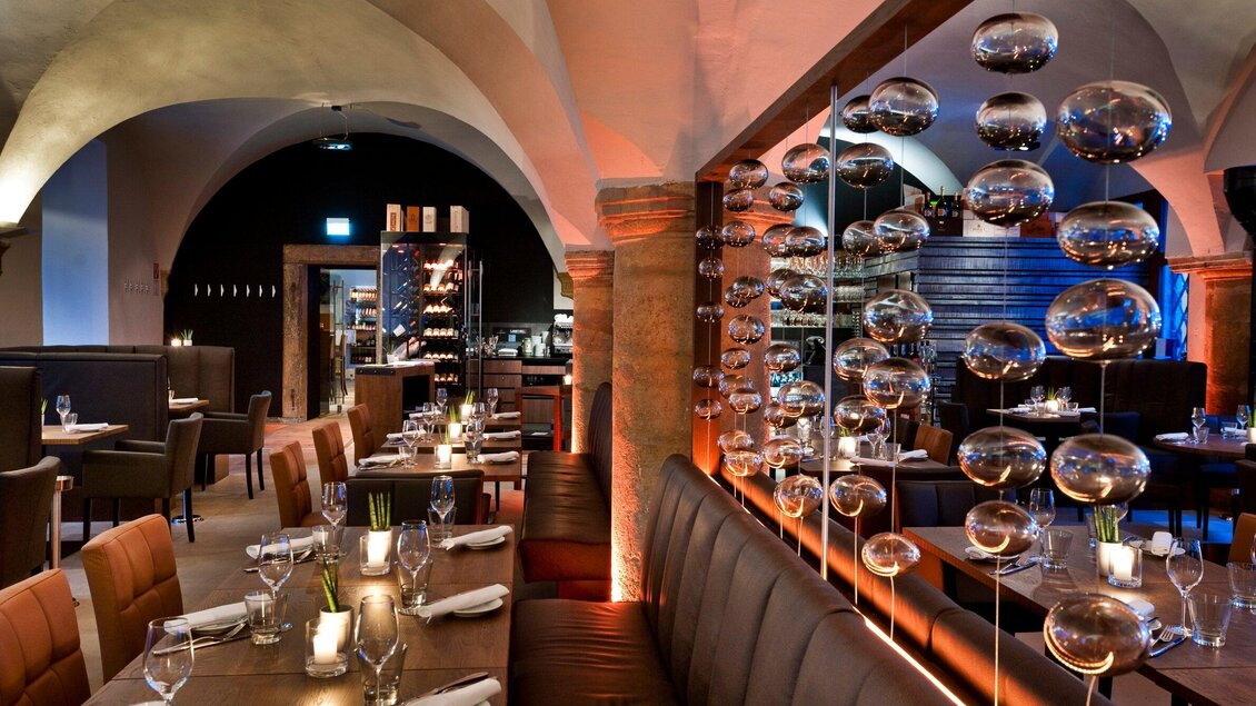 Ein elegantes Restaurant mit stilvollem Ambiente und sanfter Beleuchtung. Die Tische sind liebevoll gedeckt und es gibt eine ansprechende Wanddekoration. | © El Gaucho - Werner Krug