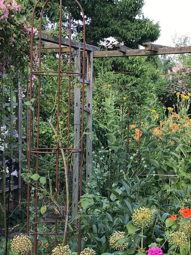 Dicht bepflanzter KunstGarten in Graz mit Blumen, Pergola und Kunstobjekten | © kunstGarten