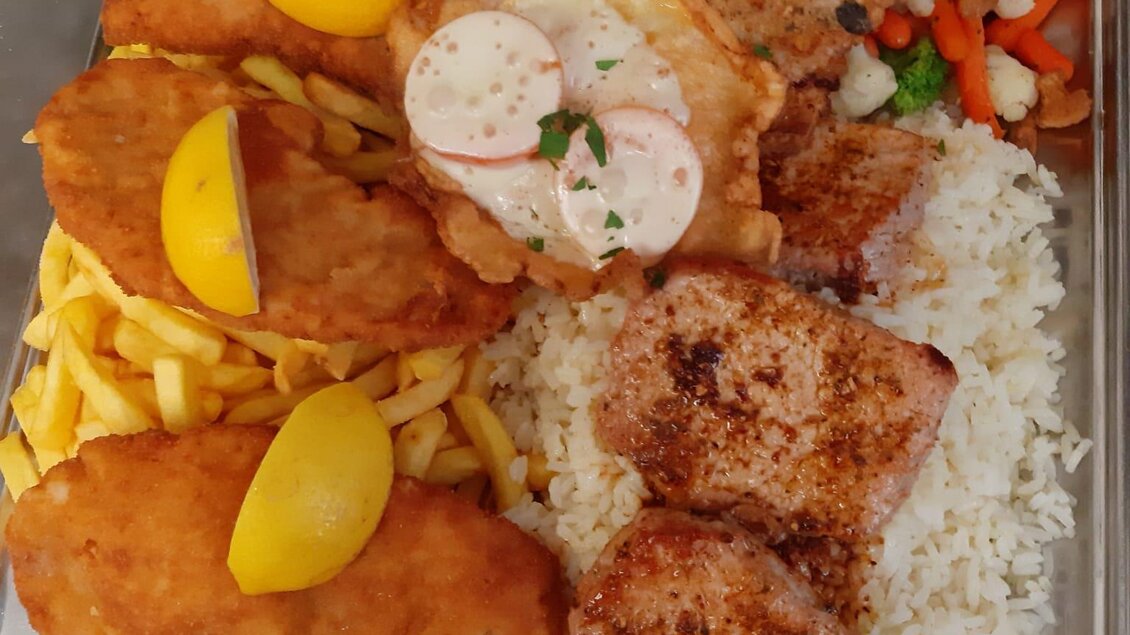 Ein Teller mit verschiedenen frittierten Fischfilets, gebratenem Hühnchen und einer Portion Reis. Dazu gibt es Pommes frites und einen Dip. | © Gasthof Pölstalerhof