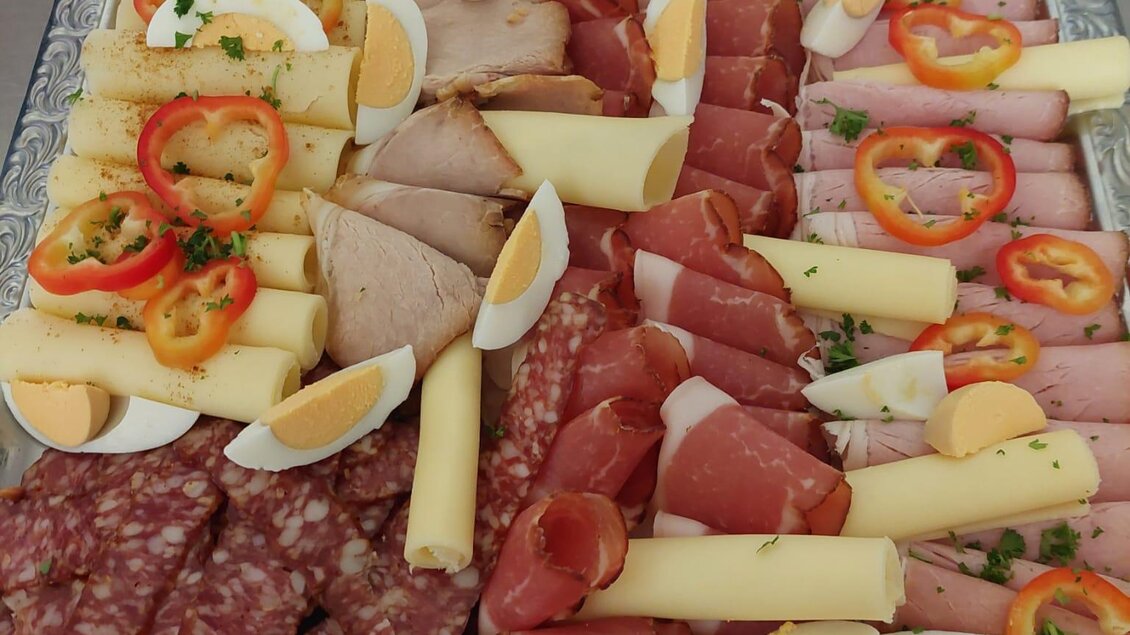 Eine Auswahl an Wurst und Käse auf einem Tablett. Frische Eier und Paprikastücke sind ebenfalls dekorativ angeordnet. | © Gasthof Pölstalerhof