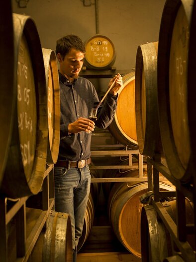 Seppi zwischen den Holzfässern im Keller | © Obsthof Neumeister, Josef Neumeister