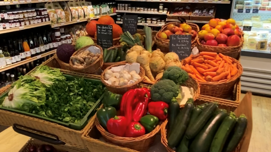 Ein Markt mit frischem Obst und Gemüse. Viele verschiedene Sorten sind in Körben angeordnet, darunter Karotten, Paprika und Zucchini. | © pur Styria - der Dorfladen