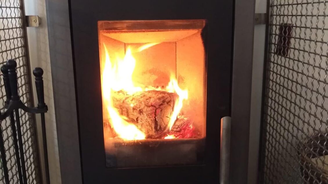 Ein moderner Kaminofen mit loderndem Feuer. Der Ofen steht in einem gemütlichen Raum und sorgt für Wärme und eine angenehme Atmosphäre. | © Jürgen Strohmeyer