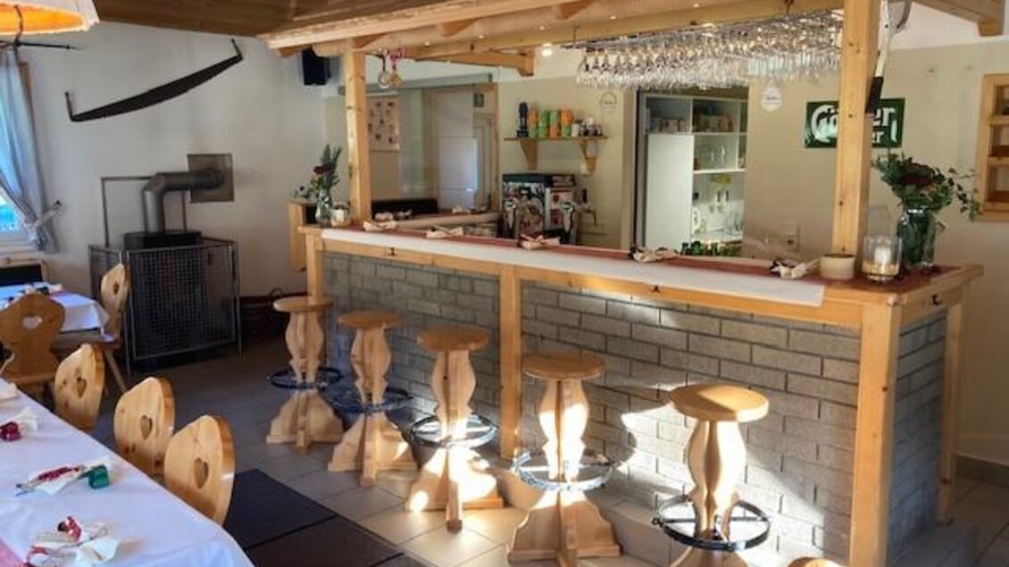 Eine gemütliche Bar mit Holzstühlen und einem einladenden Tresen. Der Raum ist hell und freundlich gestaltet, ideal für gesellige Zusammenkünfte. | © Jürgen Strohmeyer