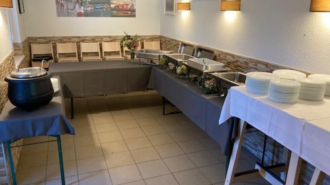 Ein Raum mit gedeckten Tischen und Buffet. Es gibt mehrere Tischgedecke und einige dekorative Elemente an den Wänden. | © Jürgen Strohmeyer