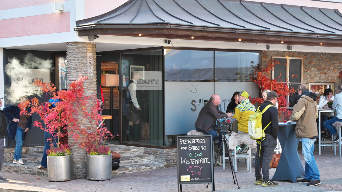Ein gemütliches Restaurant mit Terrasse und buntem Herbstlaub. Gäste sitzen draußen und genießen die Atmosphäre. | © event-fotograf.at