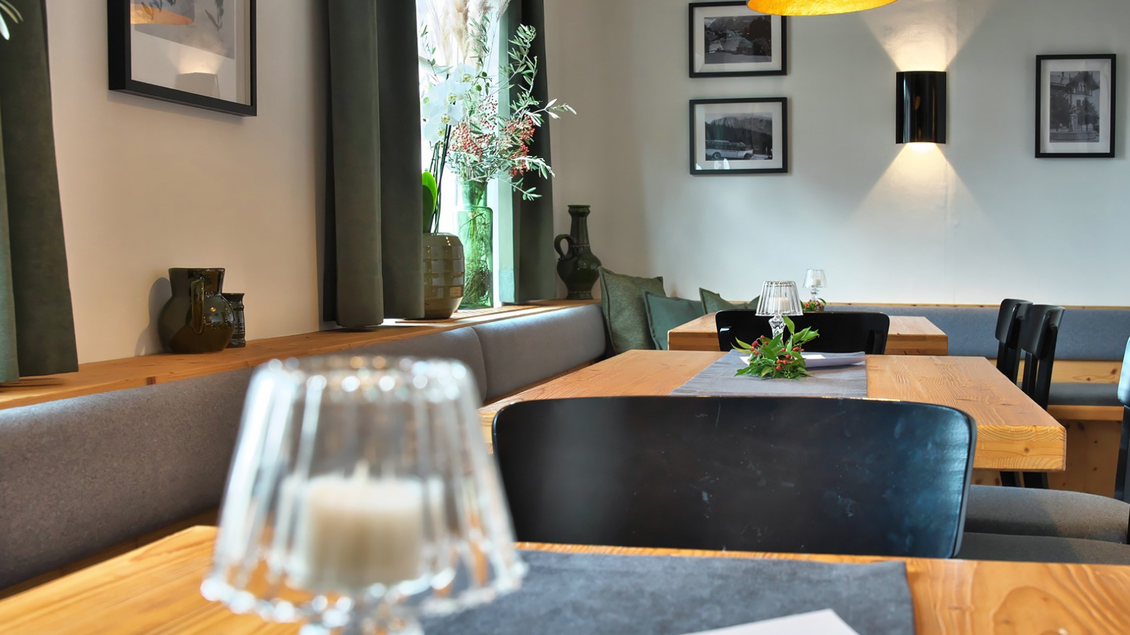 Ein gemütliches Restaurant mit Holztafeln und modernen Éinrichtungsdetails. Pflanzen und Fotografien schmücken den Raum und schaffen eine einladende Atmosphäre. | © event-fotograf.at