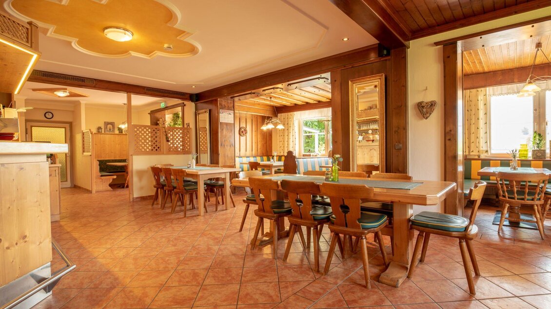 Ein gemütliches Restaurant mit Holzmöbeln und warmem Licht. Die Tische sind ordentlich angeordnet und der Raum wirkt einladend. | © s'Wirtshaus