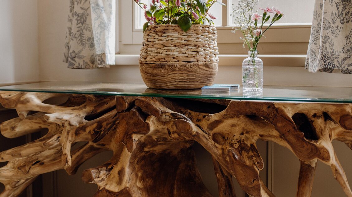 Holzskulpur mit Glasplatte und frischen Blumen | © Vagiss mi nit