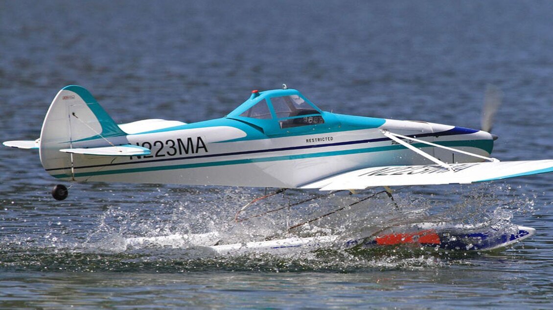 Ein Wasserflugzeug startet von der Oberfläche eines Sees. Es spritzt Wasser und hat eine auffällige blaue und weiße Lackierung. | © Ian Walter