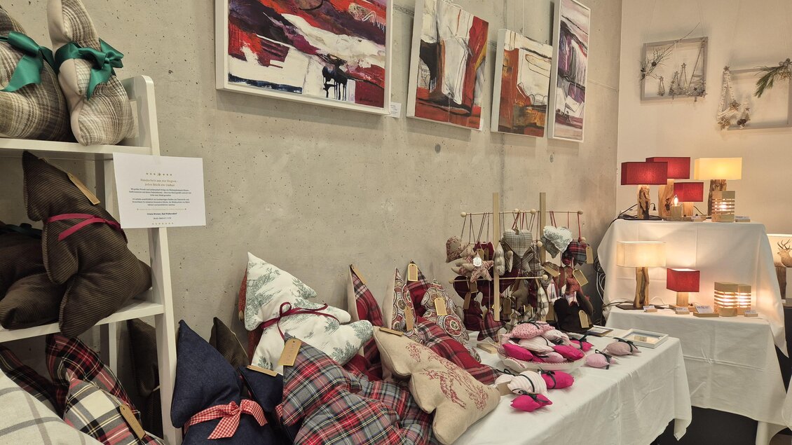 Ein gemütlicher Verkaufsstand mit dekorativen Kissen und Lampen. Die Wände sind mit modernen Kunstwerken geschmückt. | © Oststeiermark Tourismus