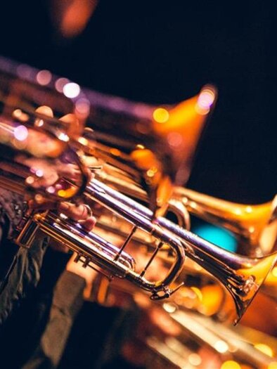 A group of trumpets in action. The instruments shine in the light and create a vibrant atmosphere. | © AdobeStock