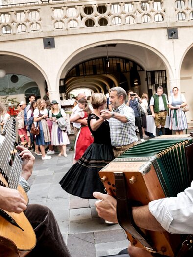 Musicians with guitar and harmonica accompany couples during folk dancing in Graz. | © Ivents Kulturagentur-Ulrike Rauch