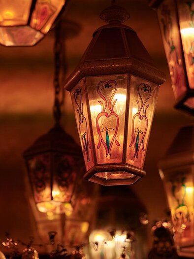 Eine Gruppe von bunten Laternen hängt an der Decke und strahlt warmes Licht aus. Die Laternen haben filigrane Muster und schaffen eine gemütliche Atmosphäre. | © pixabay.com