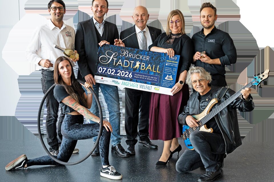 Eine Gruppe von sechs Personen posiert zusammen, während sie ein Plakat für den Brucker Stadtball halten. Der Ball findet am 07.02.2026 statt. | © Rotes Kreuz - Tamara Kury