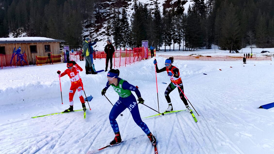 Drei Skilangläufer in einem Wettkampf auf verschneiter Strecke. Im Hintergrund sind Bäume und ein Gebäude zu sehen. | © NAZ Eisenerz