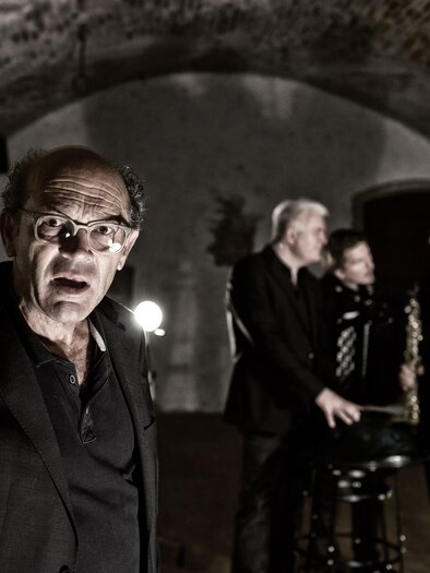 A group of four musicians stands in a subdued room. The man in the foreground speaks energetically and draws attention to himself. | © Kulturforum