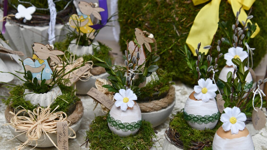 Dekorative Ostereier in verschiedenen Töpfen mit frischem Moos und kleinen Blumen. Einige Töpfe sind mit Papierfiguren von Hasen geschmückt. | © Thermen- & Vulkanland