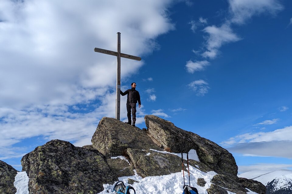 Person steht am Gipfelkreuz des Seinerkreuzes bei Hirschegg im Schnee. | © Heinz Kaltschmidt