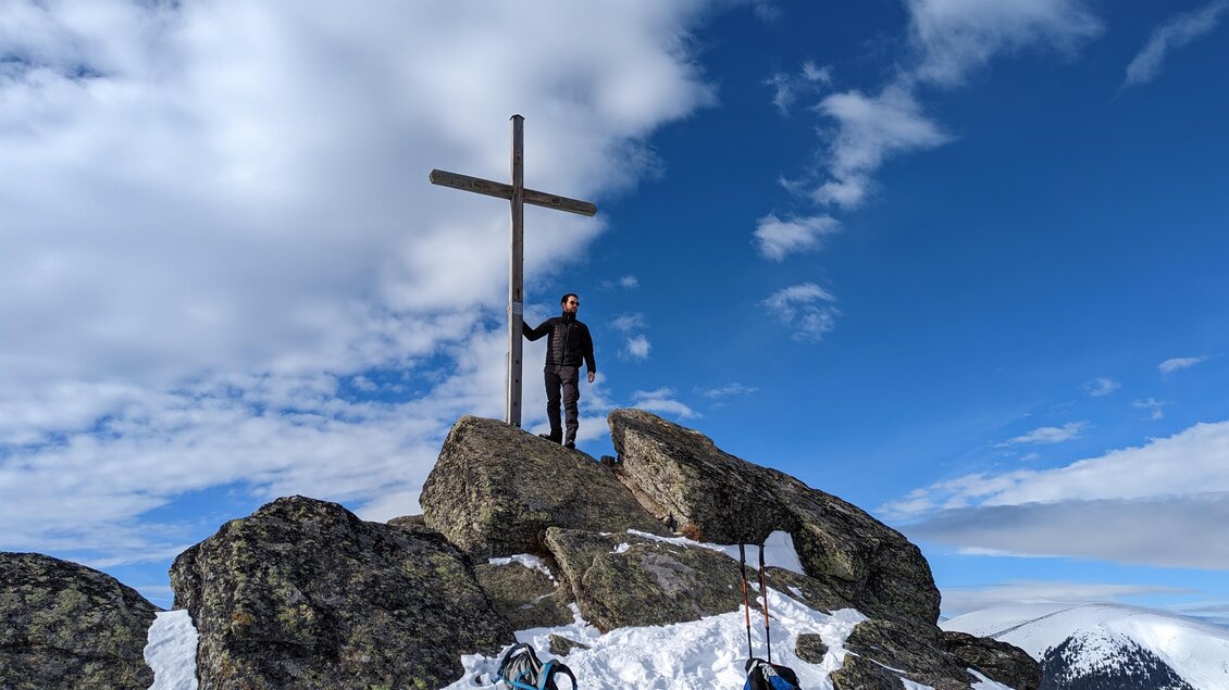 Person steht am Gipfelkreuz des Seinerkreuzes bei Hirschegg im Schnee. | © Heinz Kaltschmidt