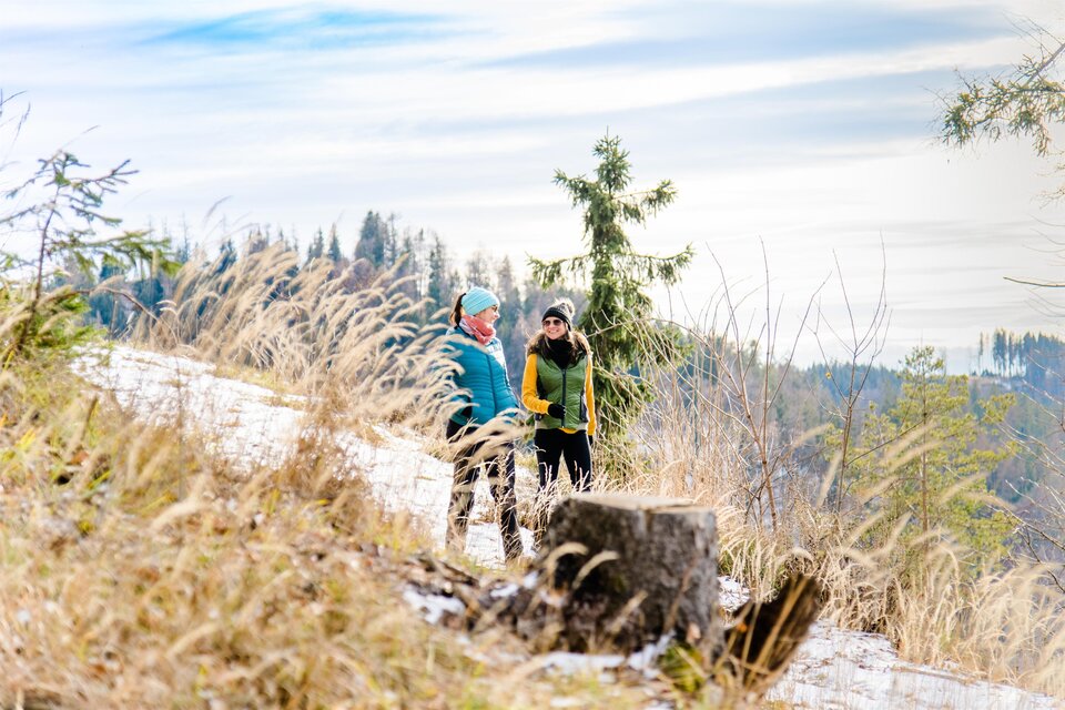 Zwei Frauen beim Winterwandern auf verschneitem Waldweg am Schöckl bei Graz. | © Region Graz-Mias Photoart